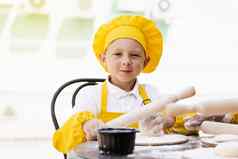 英俊的烹饪孩子黄色的厨师他围裙黄色的统一的持有面团辊烹饪面团户外