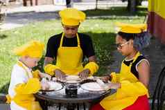 跨国公司公司孩子们厨师黄色的制服烹饪面团面包店非洲少年黑色的女孩有趣的高加索人孩子男孩烹饪食物