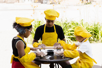 跨国公司公司孩子们厨师黄色的制服烹饪面团面包店非洲少年黑色的女孩有趣的高加索人孩子男孩烹饪食物