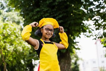 黑色的非洲孩子烹饪女孩厨师他黄色的围裙统一的触碰厨师他有创意的广告咖啡馆餐厅