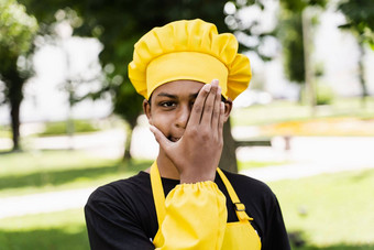 黑色的非洲少年烹饪<strong>厨师</strong>他黄色的围裙统一的隐藏脸手有创意的<strong>广告</strong>咖啡馆餐厅