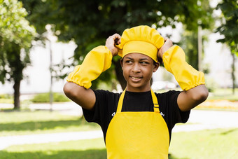 黑色的非洲少年烹饪厨师他黄色的围裙统一的触碰厨师他有创意的广告咖啡馆餐厅