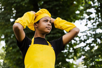 黑色的非洲少年烹饪厨师他黄色的围裙统一的触碰厨师他有创意的广告咖啡馆餐厅