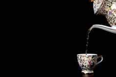倒热茶古董杯黑色的背景液体运动杯古董陶器复制空间