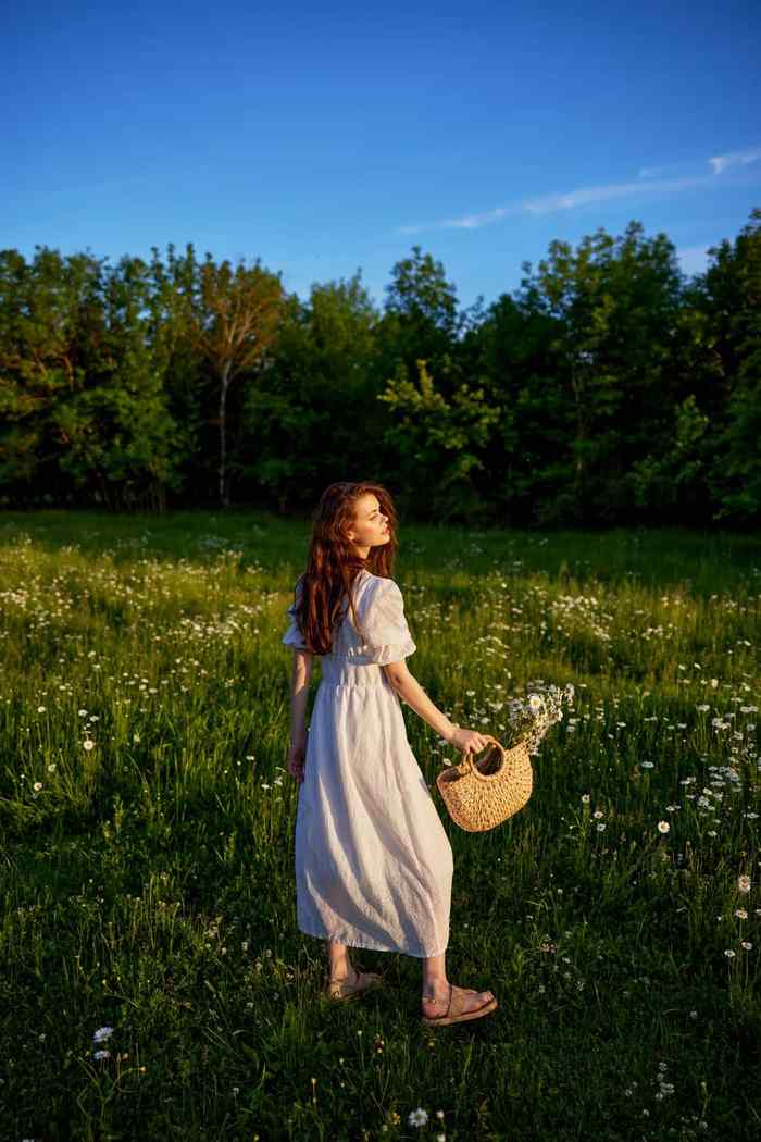 美丽的女人光光夏天衣服站开花草地日落光