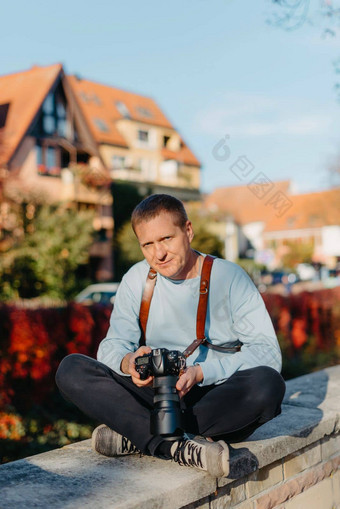 男人。坐着欧洲城市持有照片<strong>相机</strong>当代时尚的博主<strong>摄影师</strong>英俊的男人。采取自拍旅行欧洲