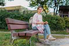 女孩享受城市视图板凳上日落日出时间美丽的金发的漂亮的女孩夏天绿色公园日落梁孤独的女人坐着时刻日落模糊背景散景光公平女孩坐着板凳上看遥远的城市风景优美的