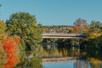 美丽的小河清洁清晰的水前面色彩斑斓的秋天树小小镇山阿加斯特不错的蓝色的云天空秋天欧洲