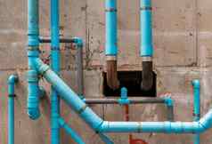 蓝色的水塑料管道混凝土墙公寓建筑安装排水管道建筑卫生系统公寓水管道系统安装混凝土天花板