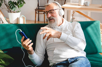 上了年纪的男人。很酷的有胡子的男人。移动电话视频调用幸福上了年纪的生活方式人概念视频调用智能手机房间挥舞着屏幕聊天孩子们现代技术沟通互联网