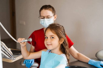 快乐的女孩孩子持有口腔学工具微笑牙科孩子微笑咨询牙医
