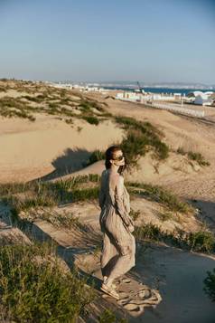 女人走沙子海多风的天气享受愉快的天气