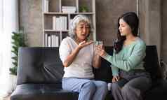 年轻的亚洲女人采取护理给玻璃水每天医学维生素补充上了年纪的医疗保健祖母