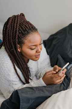 前视图非洲美国女学生穿着随便持有移动电话打字消息沟通朋友社会网络高互联网连接