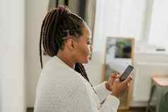 肖像非洲美国女学生穿着随便持有移动电话打字消息沟通朋友社会网络高互联网连接首页