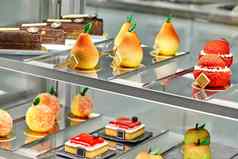 色彩斑斓的展示咖啡馆新鲜的甜蜜的蛋糕水果形状的糕点