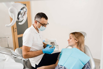 牙科假肢植入物医生牙医显示人工塑料下巴牙科植入物牙科假肢咨询牙医病人女人牙科