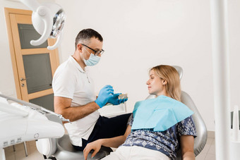 牙科假肢咨询牙医病人女人牙科医生牙医显示人工塑料下巴牙科植入物