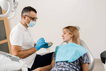牙科假肢植入物医生牙医显示人工塑料下巴牙科植入物牙科假肢咨询牙医病人女人牙科