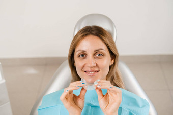 清晰的对准器咬修正形状<strong>牙齿牙齿矫正</strong>医师显示透明的可移动的护圈病人女人牙科