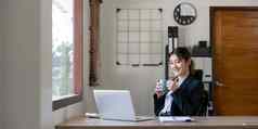 年轻的快乐专业业务女人工人员工坐着桌子上工作移动PC企业办公室微笑女电脑技术学习在线网络研究