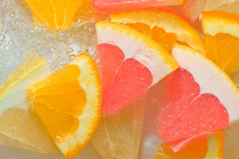 新鲜的片多汁的葡萄柚橙色水果蜂蜜葡萄柚白色背景块葡萄柚橙色水果蜂蜜葡萄柚闪闪发光的水白色背景特写镜头水平图像