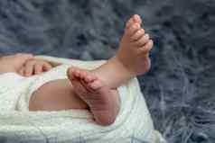 特写镜头小婴儿腿睡觉新生儿男孩白色针织毯子谎言蓝色的皮毛