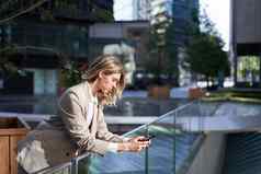企业女人移动电话女商人站在户外智能手机屏幕应用程序消息传递