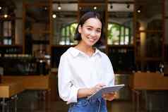 年轻的亚洲女服务员咖啡馆经理工作平板电脑图形平板电脑