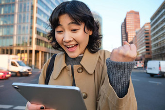 热情的亚洲女孩数字<strong>平板</strong>电脑<strong>微笑</strong>惊讶快乐好持有数字<strong>平板</strong>电脑站街