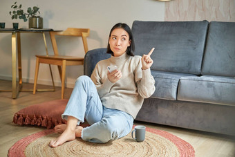 肖像女人坐着地板上智能手机深思熟虑的指出手指横幅<strong>促销广告</strong>前角落里