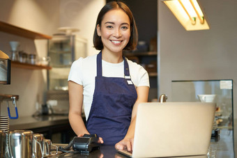 微笑亚洲女孩咖啡师工作咖啡馆服务客户端移动PC卡读者收到钱订单销售咖啡