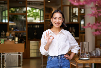 微笑快乐亚洲女人企业家推荐咖啡馆显示标志批准