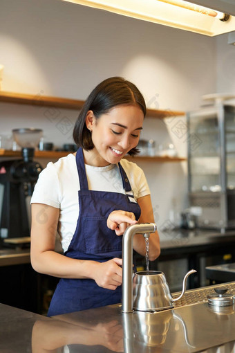 垂直拍摄咖啡师女孩咖啡商店倒水水壶准备订单咖啡馆微笑相机