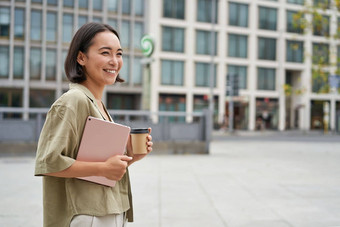 时尚的城市女孩平板电脑走街喝外卖咖啡大学工作