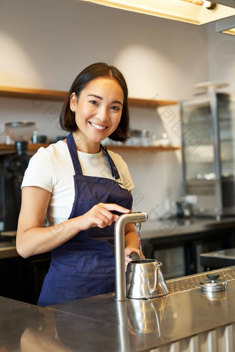 垂直拍摄咖啡师女孩咖啡商店<strong>倒水水壶</strong>准备订单咖啡馆微笑相机