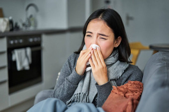肖像生病了年轻的朝鲜文女人感觉生病的打喷嚏持有餐巾住首页生病了抓住了冷