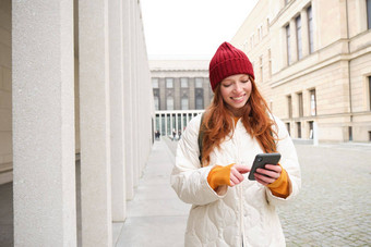 旅游技术美丽的红色头发的人女孩旅游路线应用程序城市地图智能手机阅读观光的地方移动电话