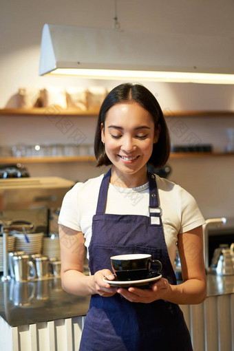 垂直拍摄友好的亚洲女孩微笑服务咖啡咖啡师给杯咖啡准备喝客户端咖啡馆
