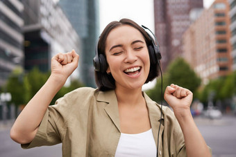 <strong>跳舞女</strong>孩感觉快乐城市亚洲女人<strong>跳</strong>舞听音乐耳机摆姿势街