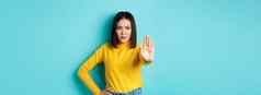 自信亚洲女人显示停止手势禁止警告不同意站心烦意乱蓝色的背景