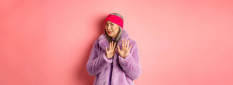 肖像时尚的亚洲高级女人紫色的冬天外套畏缩恶心的皱着眉头转尴尬的显示停止手势拒绝粉红色的背景