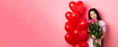 情人节一天概念温柔的温柔的十几岁的女孩持有浪漫的花站红色的心气球情人盯着爱站粉红色的背景