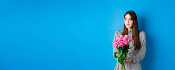 情人节一天概念漂亮的浪漫的女孩梦幻空空间持有花束粉红色的玫瑰日期站蓝色的背景