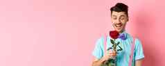 情人节一天浪漫概念快乐的男朋友红色的玫瑰等待情人蝴蝶结站粉红色的浪漫的背景