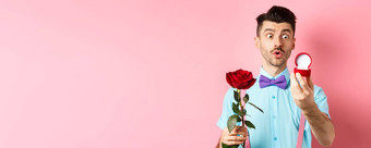 情人节一天浪漫的有趣的的家伙使婚礼建议结婚持有红色的玫瑰订婚环兴奋粉红色的背景