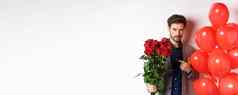 英俊的男人。西装浪漫的情人节一天日期指出花束玫瑰站心气球白色背景