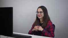 年轻的女人会说话的视频链接坐着办公室前面爱知县专家眼镜红色的衬衫