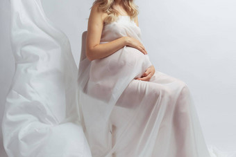 特写镜头优雅的怀孕了年轻的女人站穿飞行白色织物怀孕孕妇母亲概念