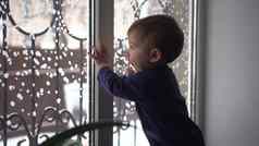 小孩子站窗台上窗口孩子敲门玻璃冬天